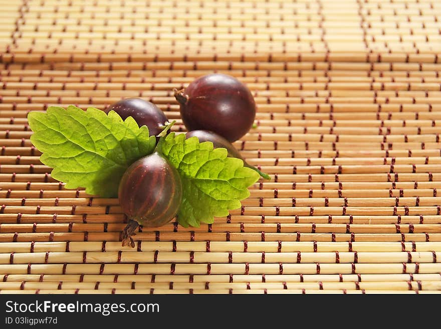 Delicious summer gooseberries with green leaves.