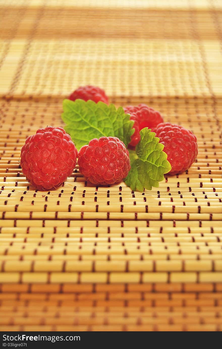 Delicious summer raspberries with green leaves.