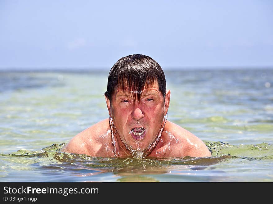 Portrait of a man swimming in the crystal clear ocean. Portrait of a man swimming in the crystal clear ocean