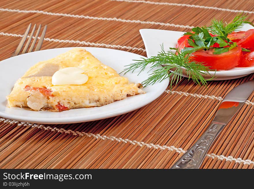 Portion of an omelette with tomatoes and bacon