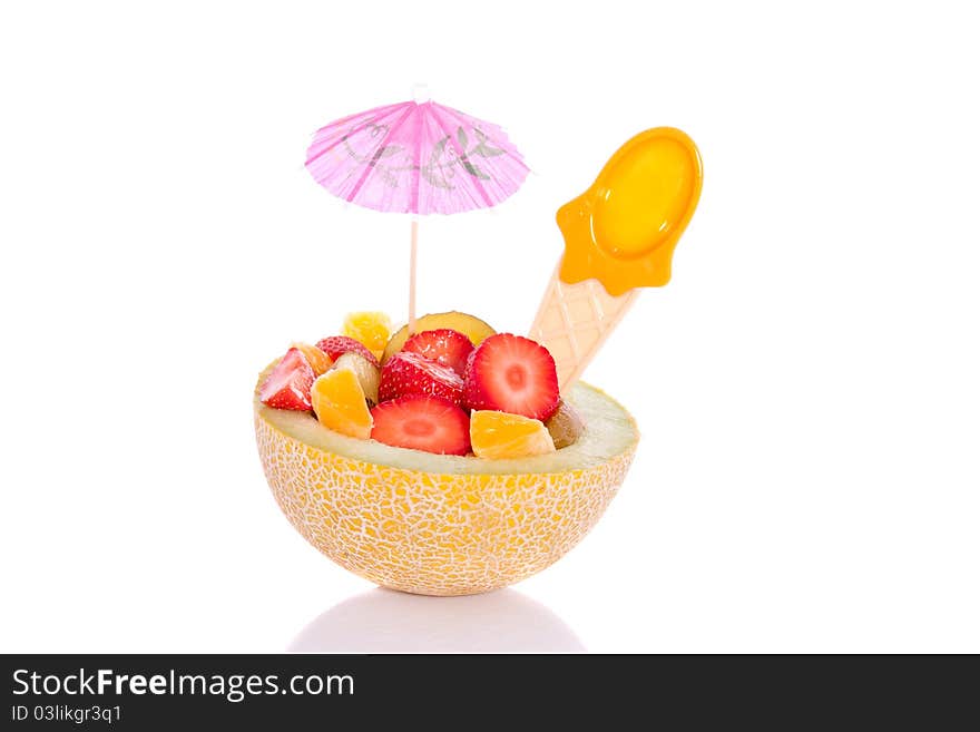 A fresh fruit salad in a hollowed melon nicely decorated and isolated over a white background