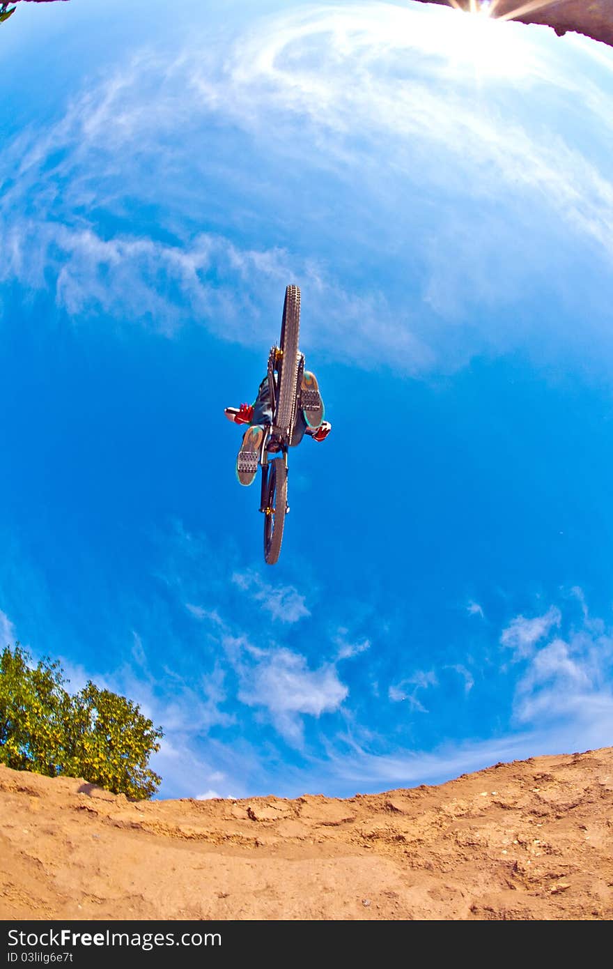 Boy has fun jumping with his dirtbike under blue sky. Boy has fun jumping with his dirtbike under blue sky