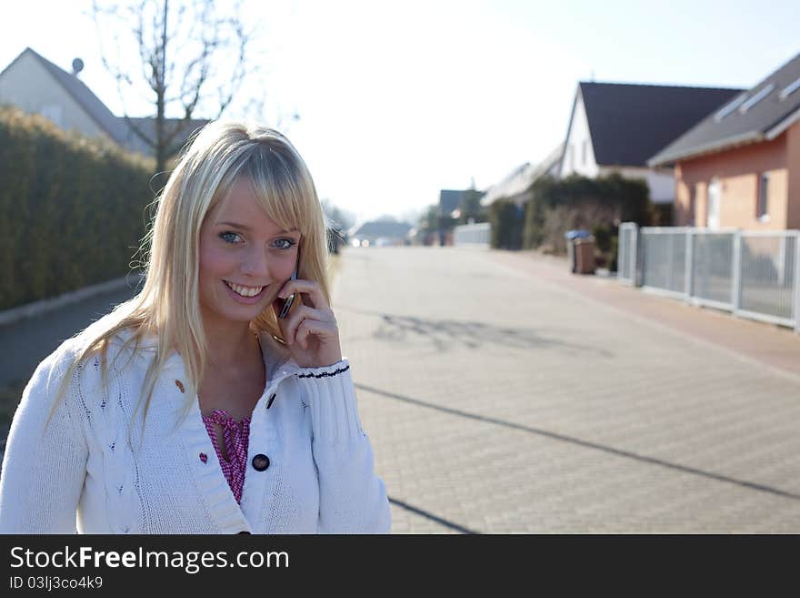 Woman with a cell phone on a village street