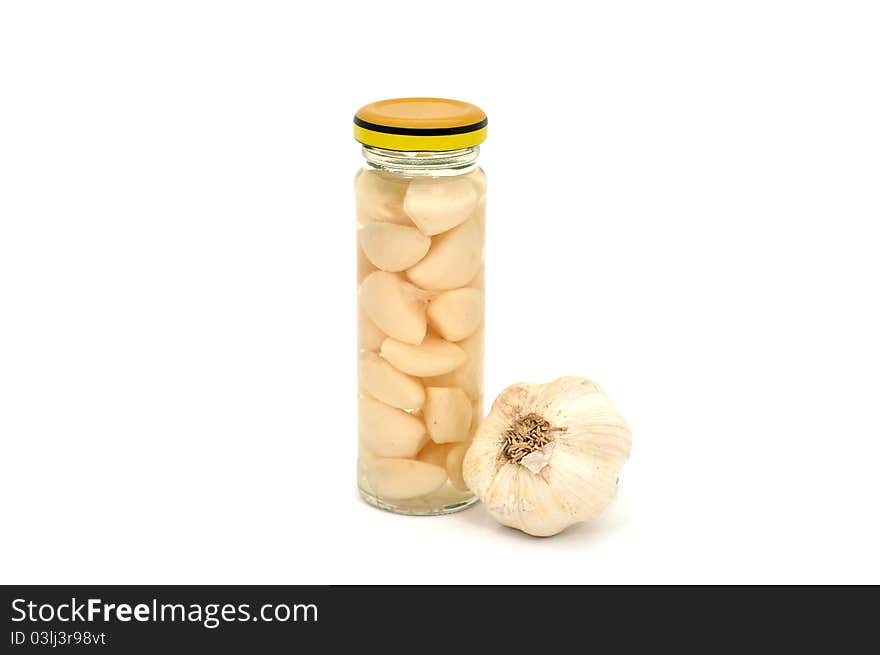 Preserved garlic in a narrow glass jar. Preserved garlic in a narrow glass jar