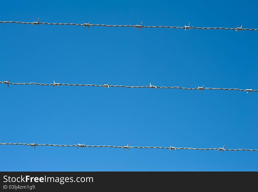 Image of a barbed wire against the blue sky