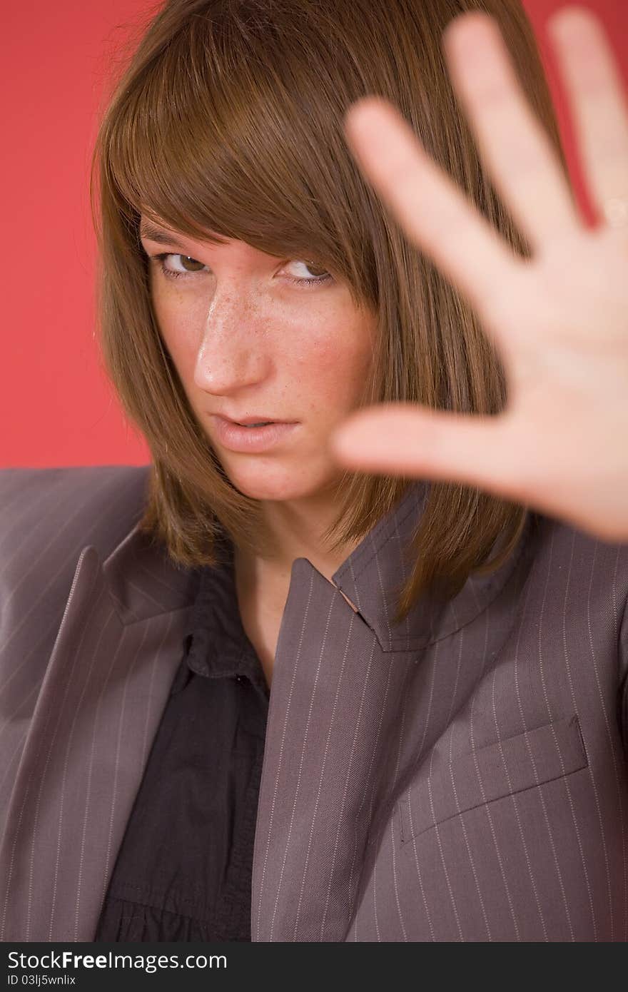 Woman in formal suit making a stop sign with hand