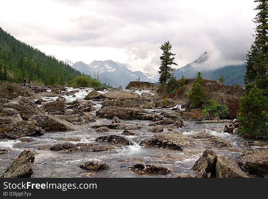 Cloudy day on the bank of the mountain river among sharp stones. Cloudy day on the bank of the mountain river among sharp stones