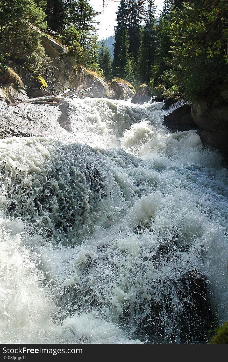 Rough falls in wild gorge between huge stones