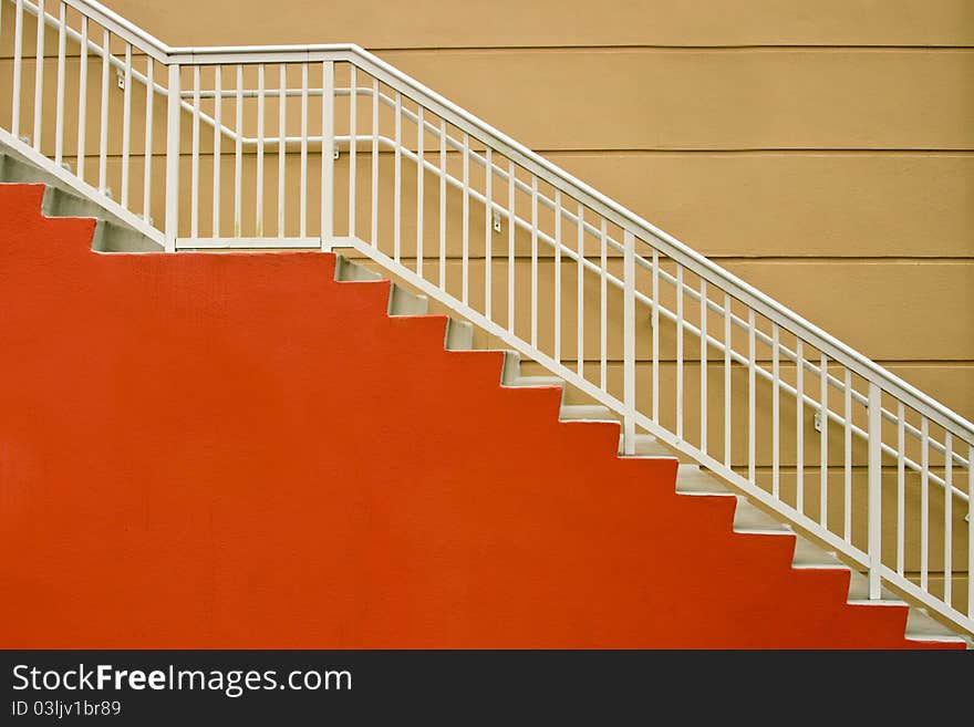 Red and white stairway against mustard- colored wall