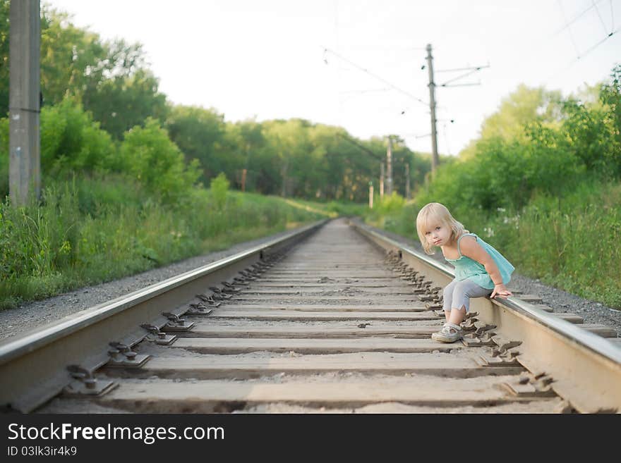 Adorable girl sit on rail wait for train