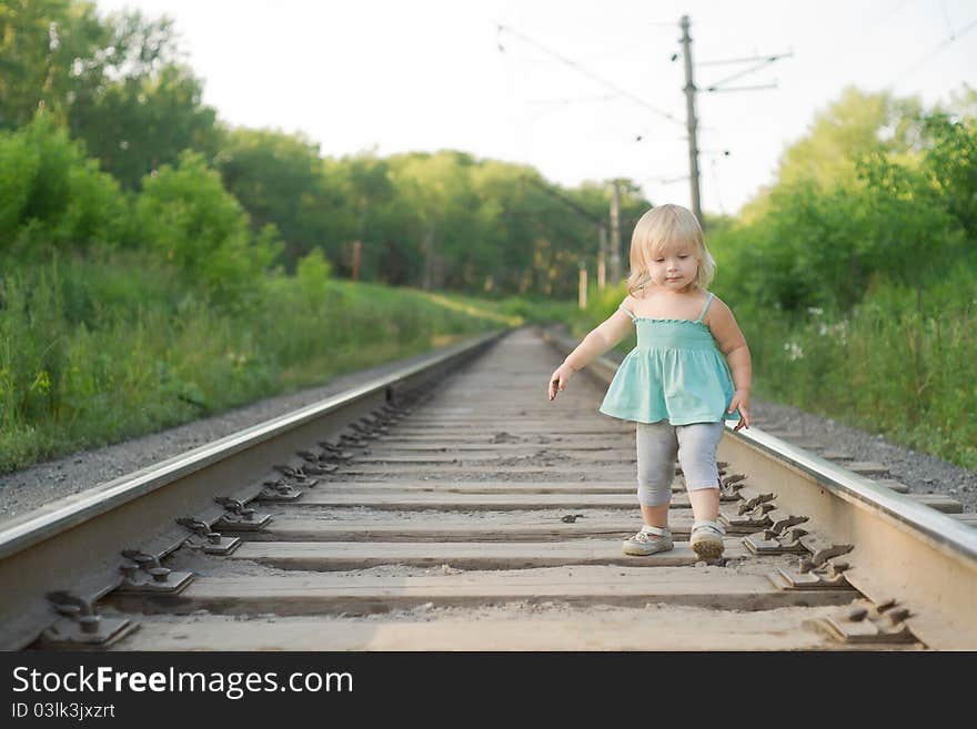 Adorable girl walk along rails