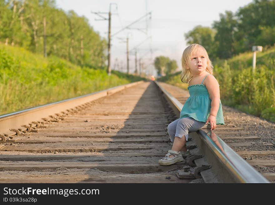 Adorable girl sit on rail wait for train