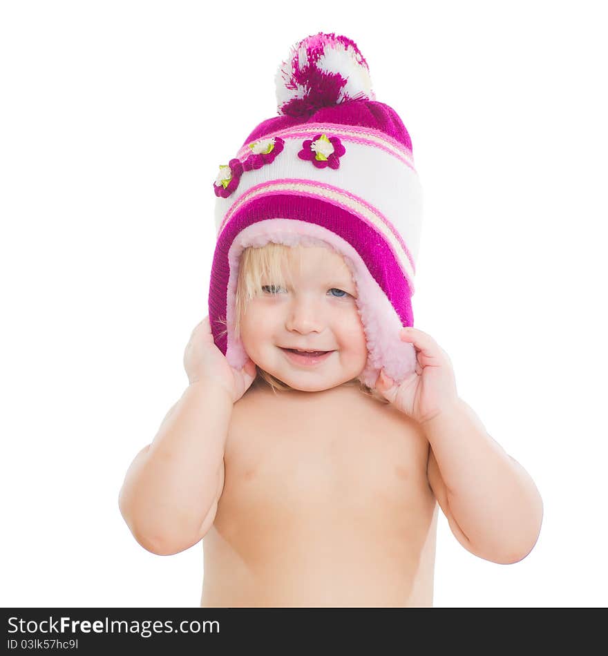 Adorable girl putting on winter hat on head