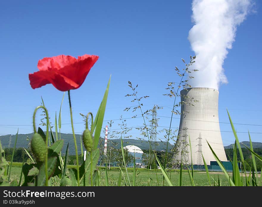 Nuclear power plant with red poppy flower in the foreground. Nuclear power plant with red poppy flower in the foreground