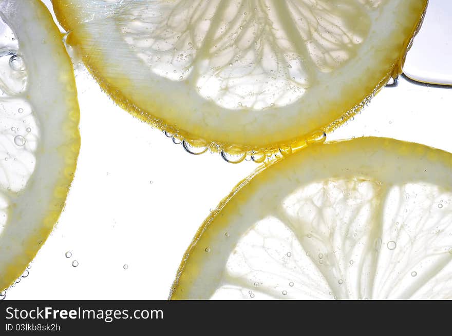 Slice of lemon in the water with bubbles