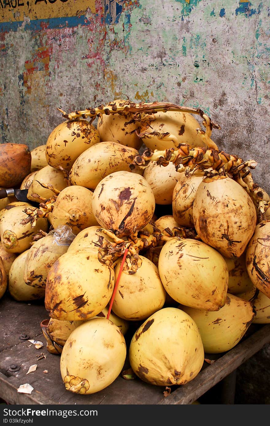 Bunch of yellow coconuts against a wall. Bunch of yellow coconuts against a wall