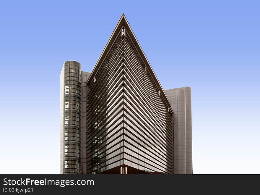 A Glass Office Block shaped like an ocean liners bows against a blue sky with reflections. A Glass Office Block shaped like an ocean liners bows against a blue sky with reflections