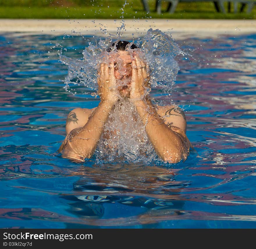 Man swimming in the pool with water splashing