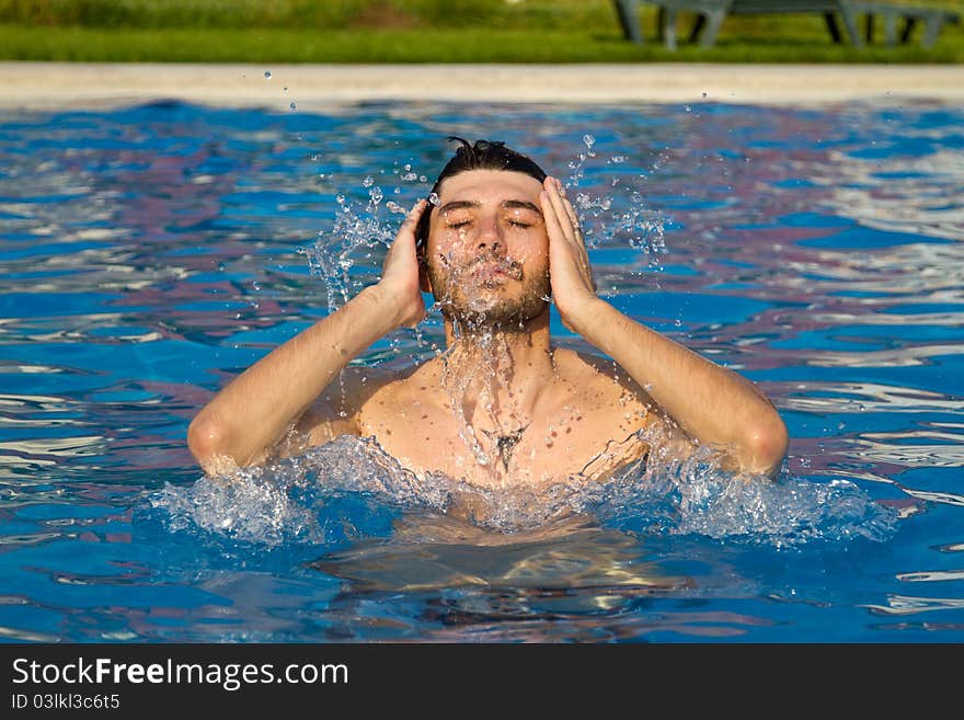 Man swimming in the pool with water splashing