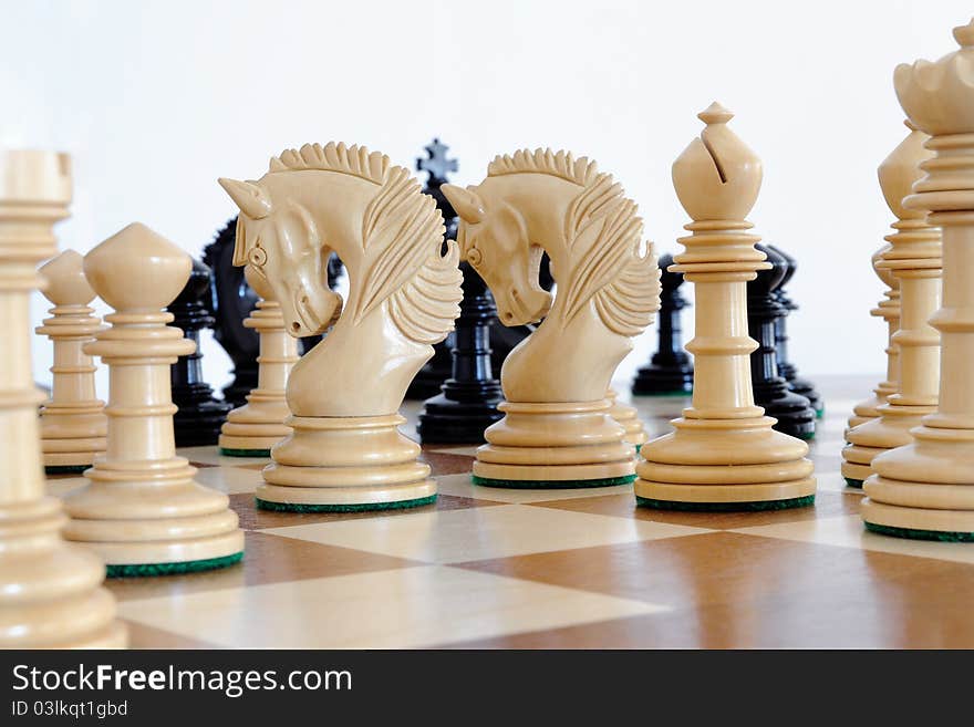 Chess pieces on wood board, black and white