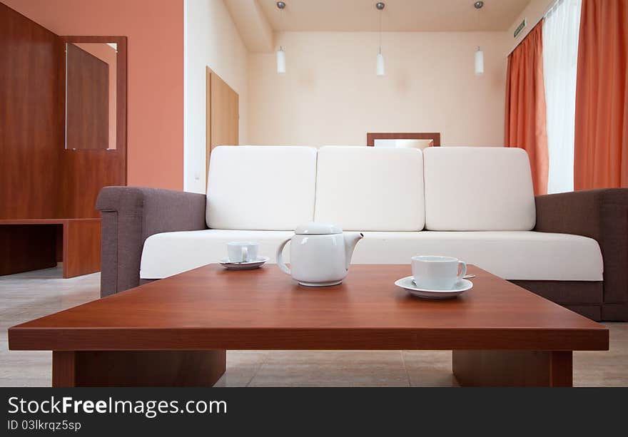 Teapot and cups on the background of the sofa