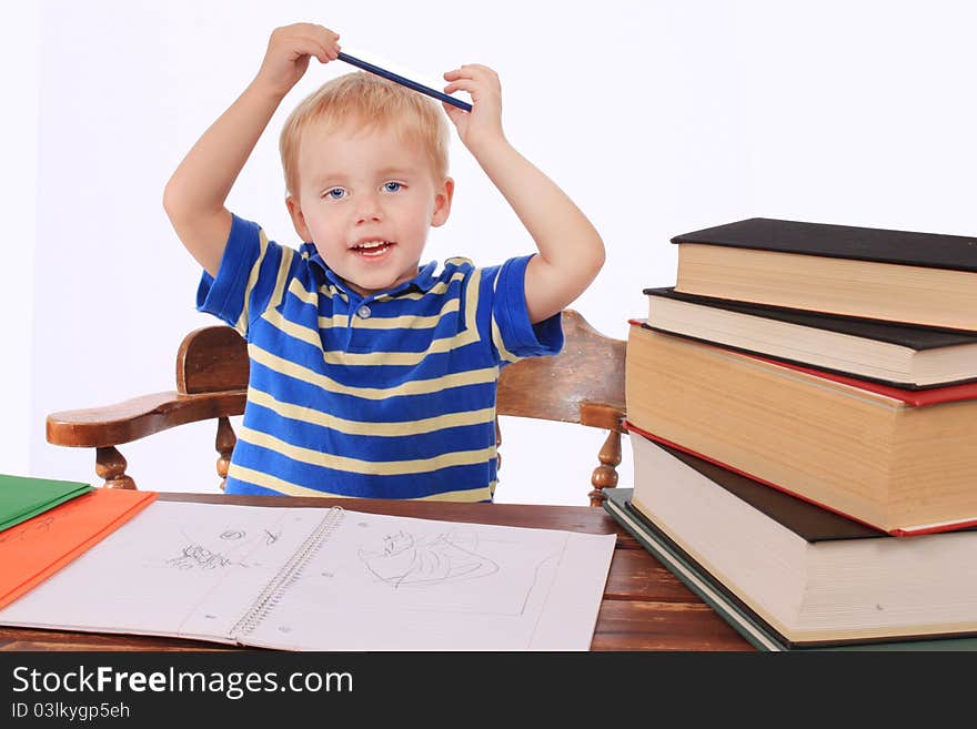 Toddler at a desk, bored and playing with a pencil. Toddler at a desk, bored and playing with a pencil