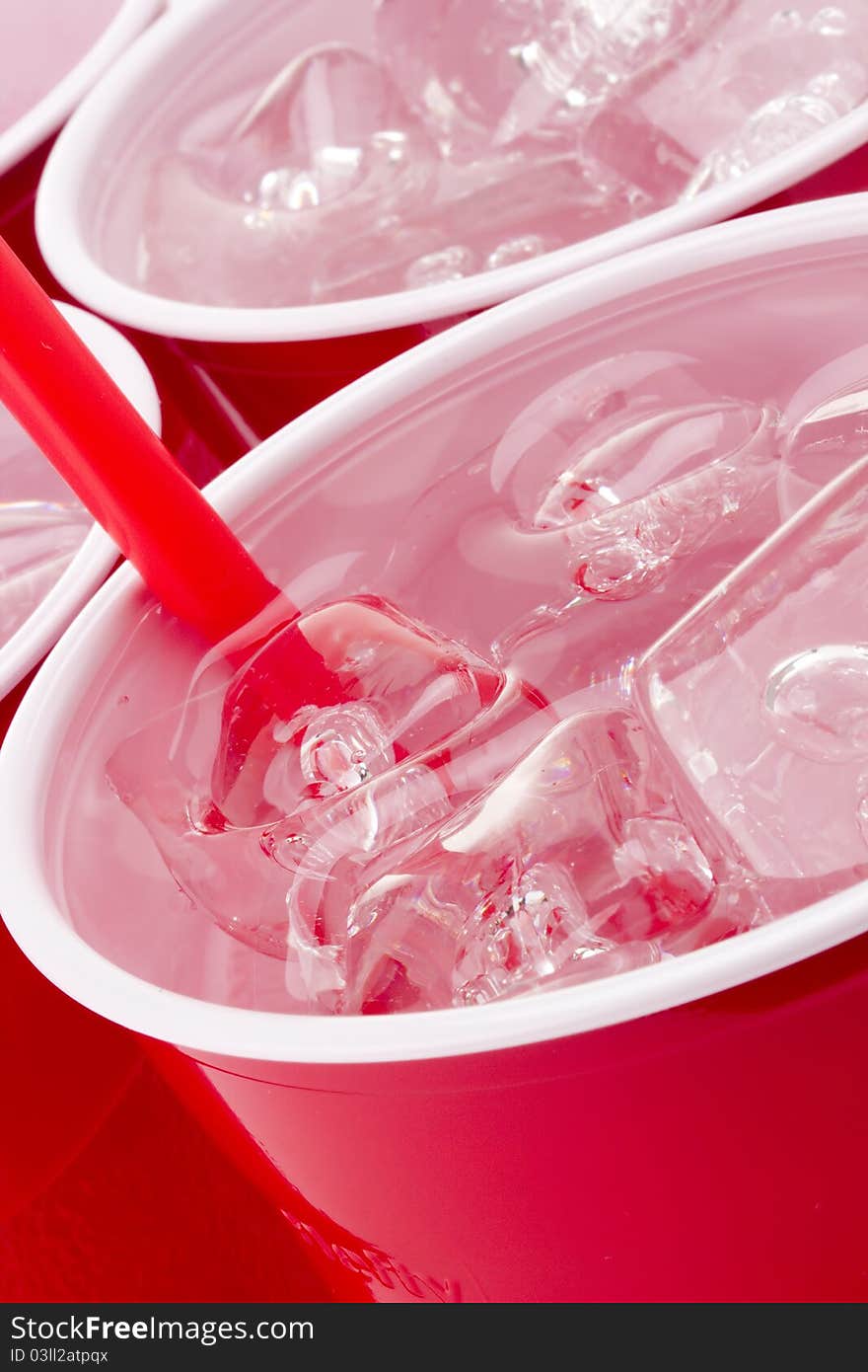 Water and ice in a red disposable cup. Water and ice in a red disposable cup.