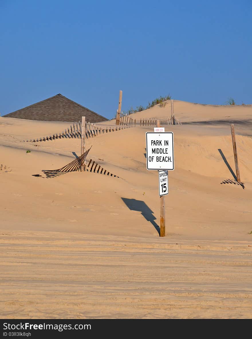 Sign encouraging beach patrons to park in the middle of the beach. Sign encouraging beach patrons to park in the middle of the beach