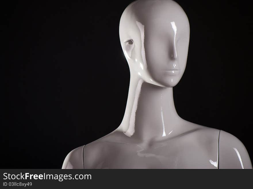 Head of female fashion mannequin against a black background