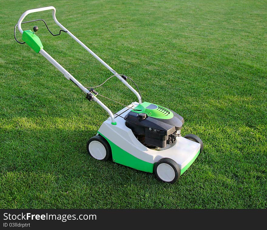 Mower is on the lawn with green grass background