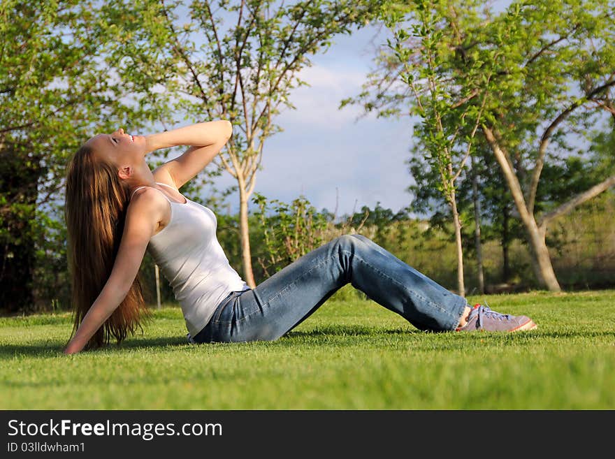 Girl sitting on the lawn and talking on the phone. Girl sitting on the lawn and talking on the phone