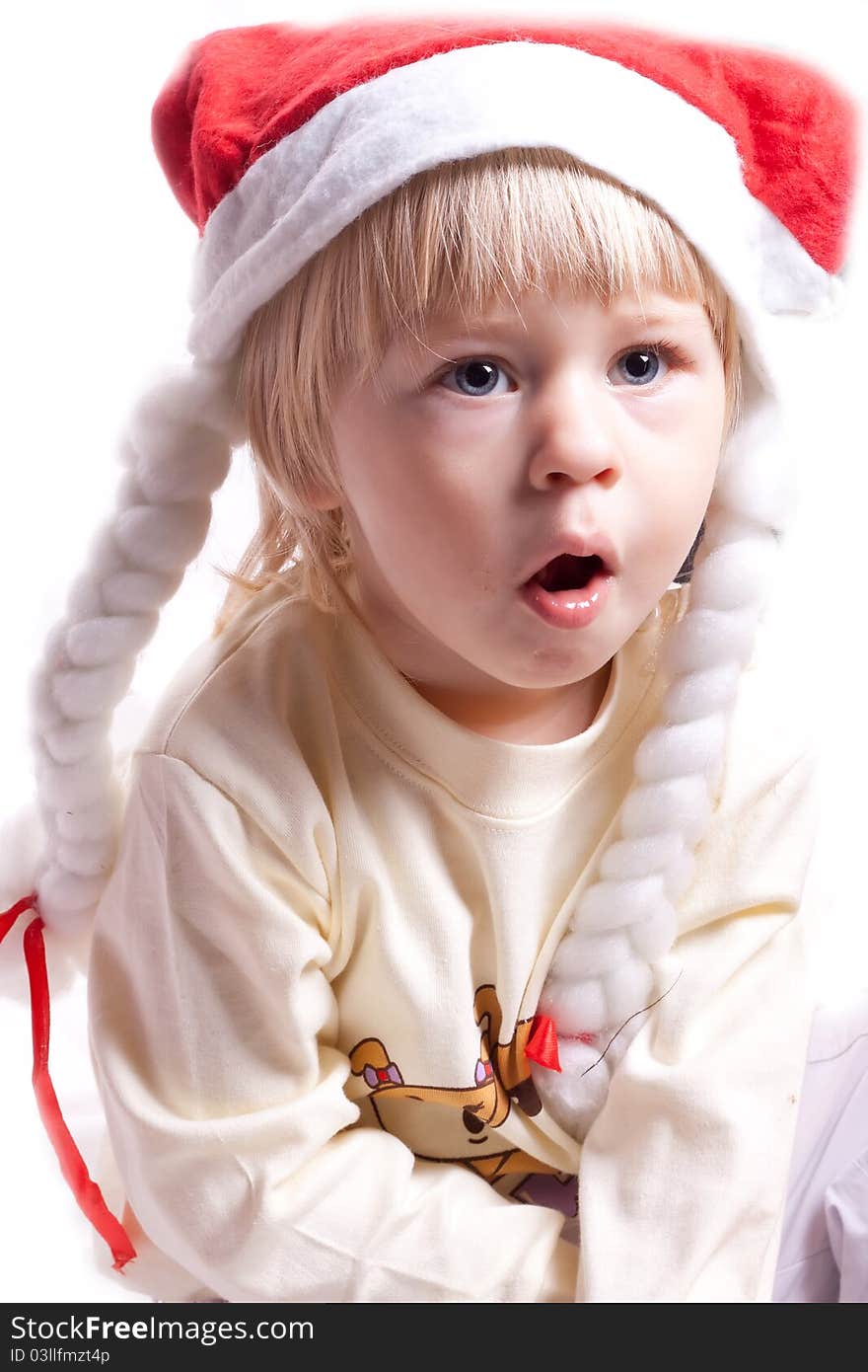 Little girl in a Christmas hat with braids on a white background