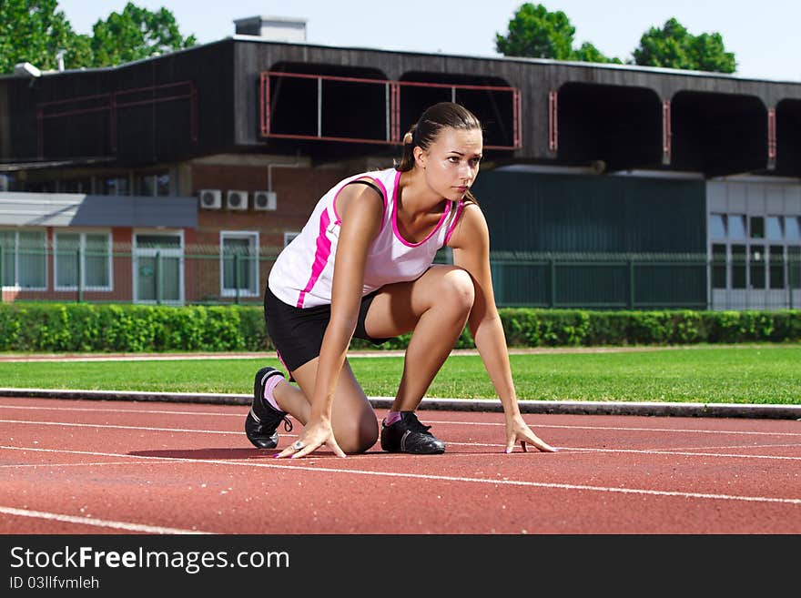 Young woman in sprinting position