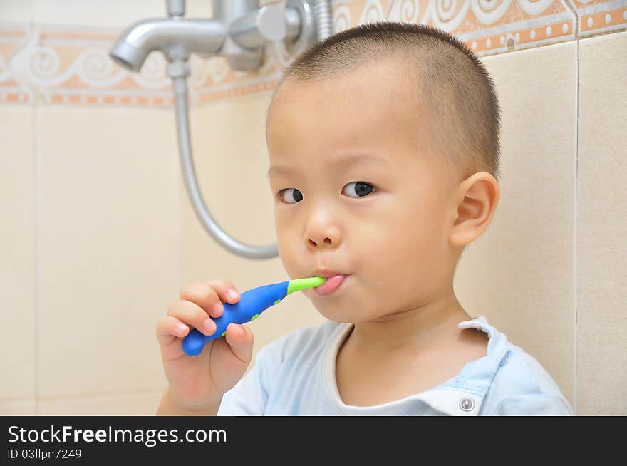 A chinese boy is brushing his teeth in bathroom. A chinese boy is brushing his teeth in bathroom