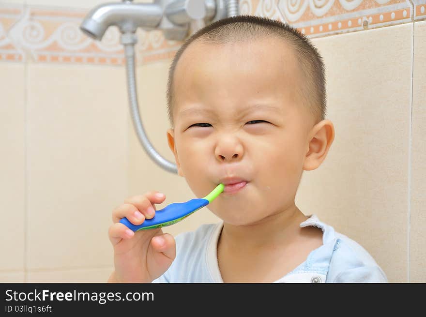 A chinese boy is brushing his teeth in bathroom. A chinese boy is brushing his teeth in bathroom