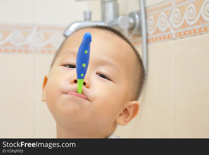 A chinese boy is brushing his teeth in bathroom. A chinese boy is brushing his teeth in bathroom