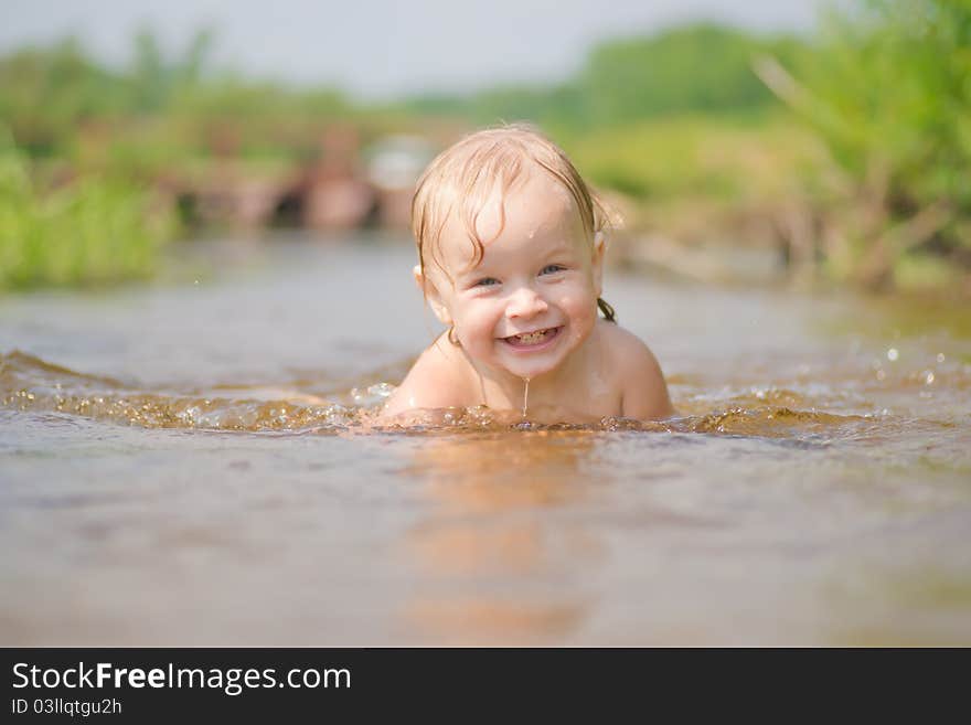 Adorable young baby swim in river