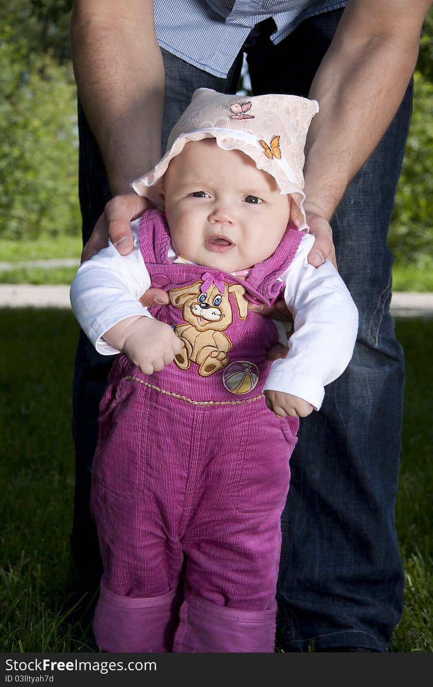 Father playing with baby, raised it high above them, against the background of blue sky. Father playing with baby, raised it high above them, against the background of blue sky