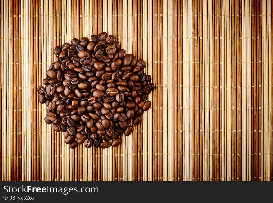 Handful aromatic coffee beans on brown background