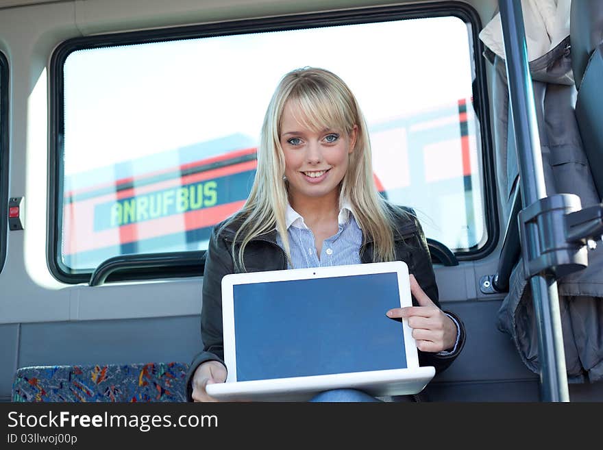 Woman points at the laptop-display inside a bus