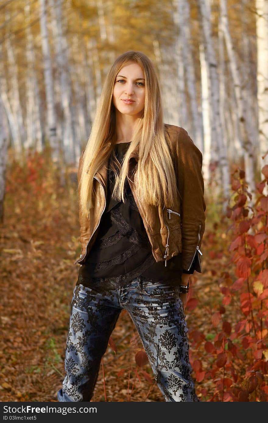 Young attractive smiling girl in autumn park