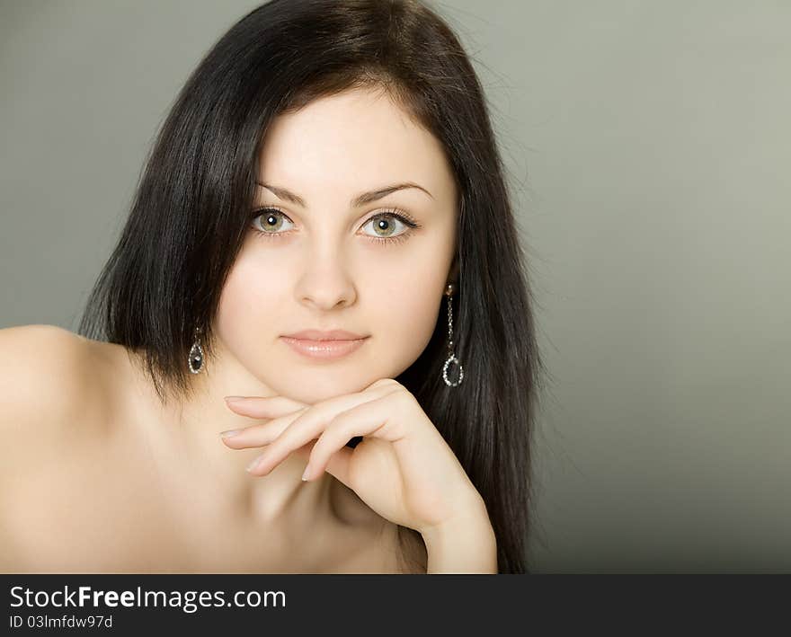 Beautiful brunette girl оn a gray background