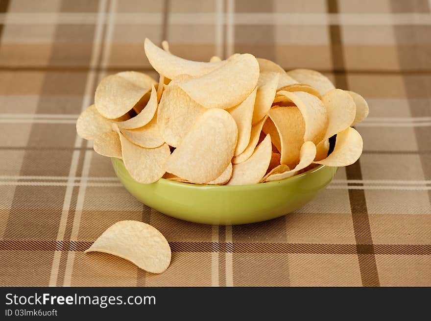 Delicious potato chips in green bowl