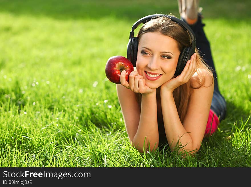 Woman with headphones listening music on the grass