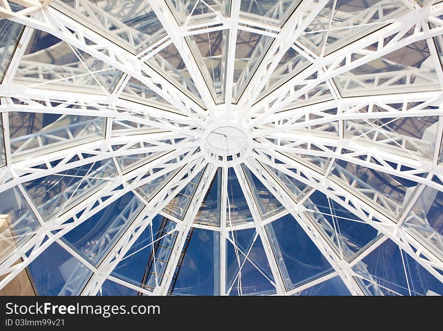 Inside view of the building through the glass roof on blue sky. Inside view of the building through the glass roof on blue sky