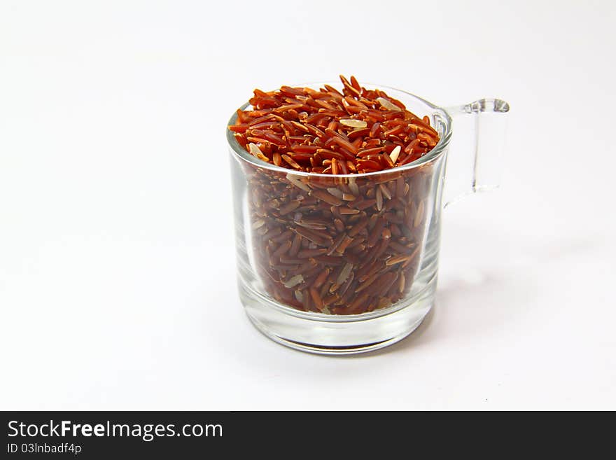 Red jasmine rice and beaker on a white background