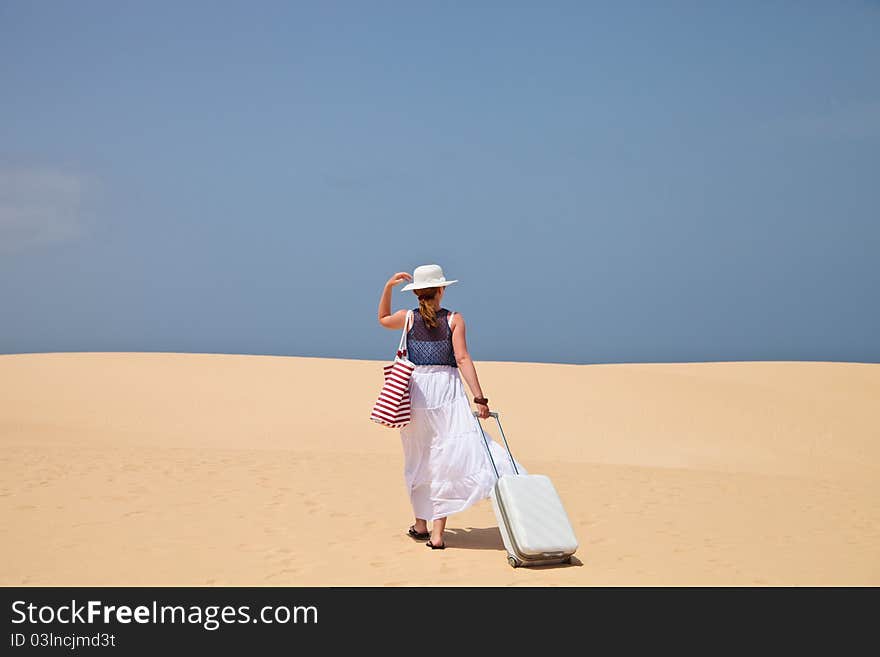 Woman walking on a sand to the sea