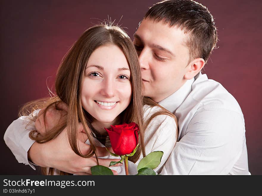 Beautiful couple in love with rose on black background