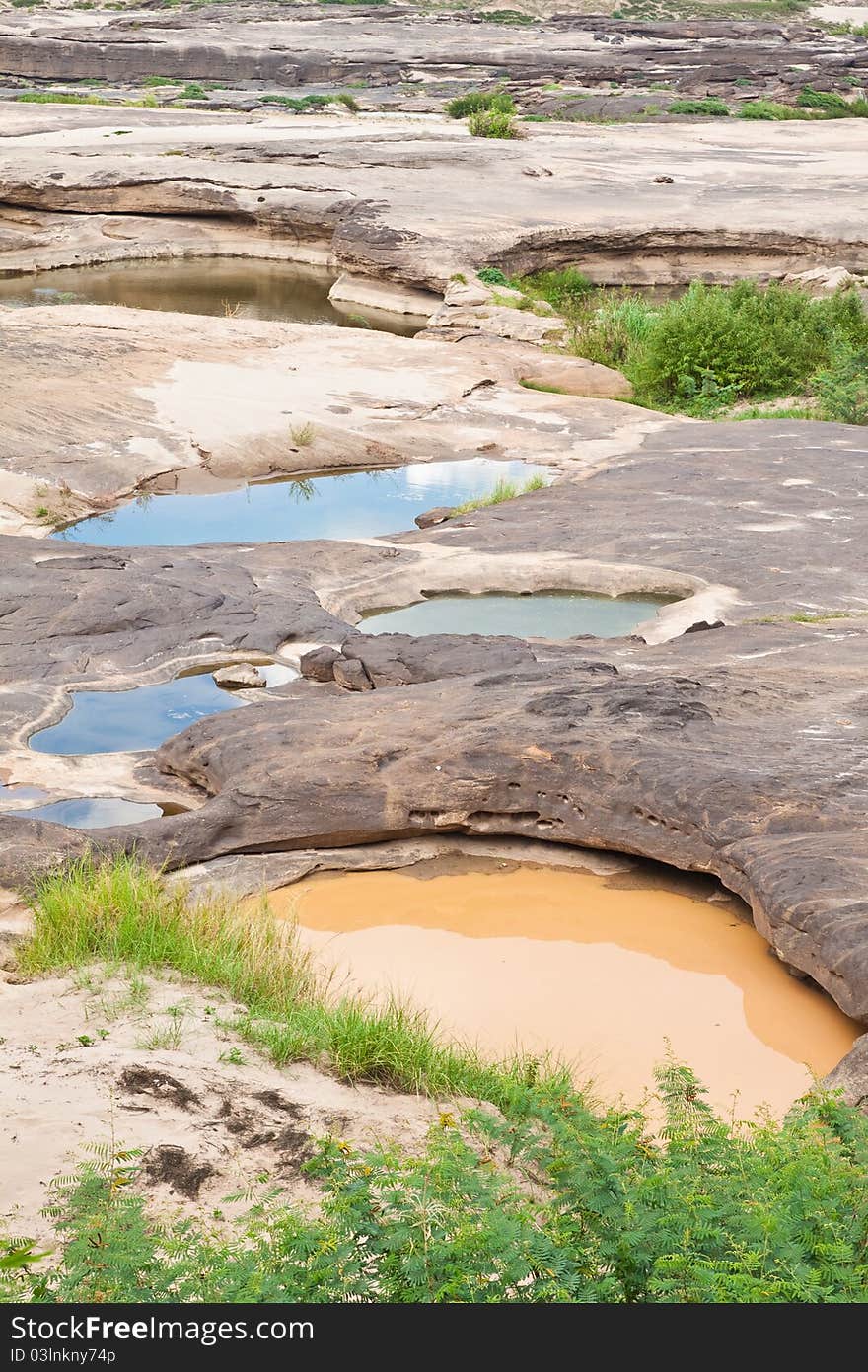 Two color water in the hole of rock in Khong River after the water come down