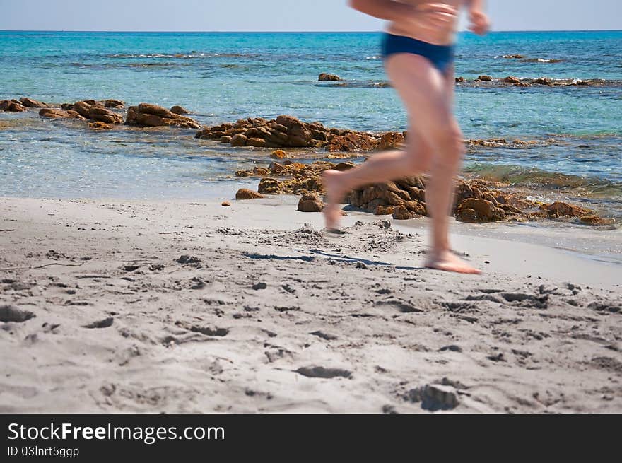 Man running on the beach in summer